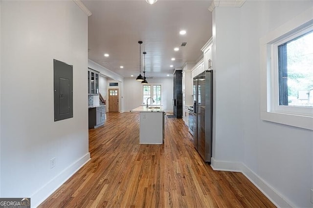 1120 Arlington Ave SW, Atlanta, GA 30310 - kitchen with electric panel, an island with sink, white cabinetry, dark wood-style floors, and baseboards