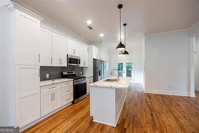 1120 Arlington Ave SW, Atlanta, GA 30310 - kitchen with a sink, stainless steel appliances, white cabinets, a center island with sink, and ornamental molding