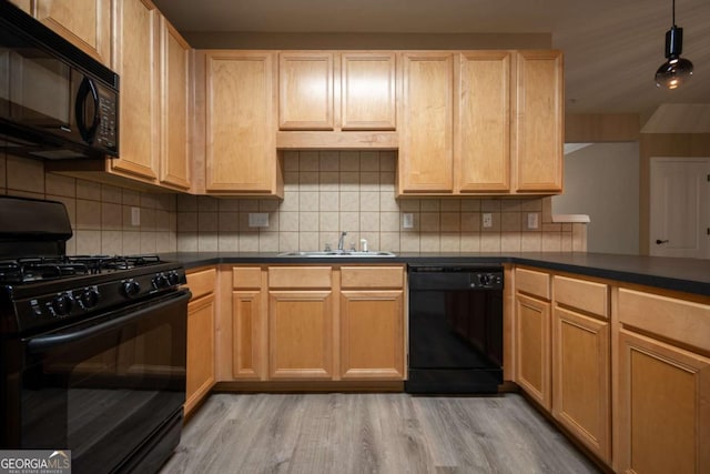96 Portico Pl, Newnan, GA 30265 - kitchen with light wood finished floors, dark countertops, black appliances, and a sink