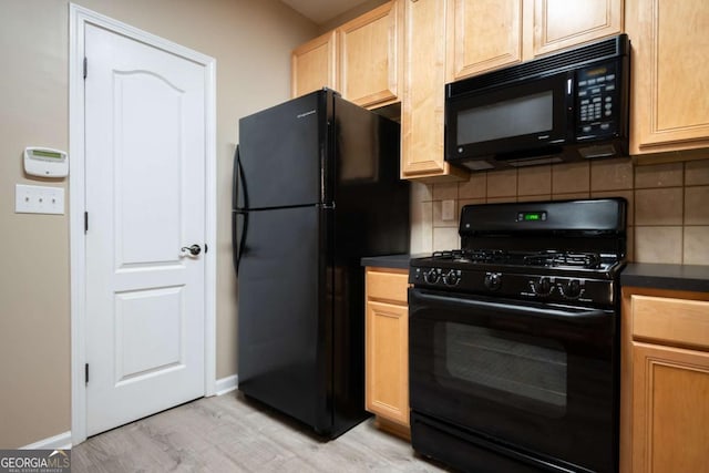 96 Portico Pl, Newnan, GA 30265 - kitchen with black appliances, backsplash, baseboards, dark countertops, and light wood-style floors