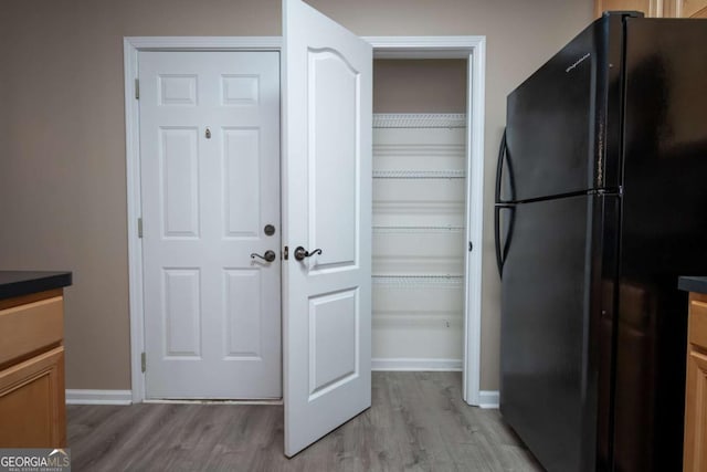 96 Portico Pl, Newnan, GA 30265 - kitchen with freestanding refrigerator, dark countertops, light wood-type flooring, and baseboards