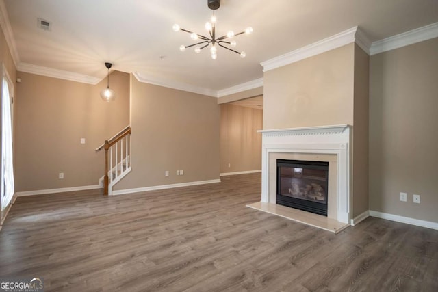 96 Portico Pl, Newnan, GA 30265 - unfurnished living room with wood finished floors, crown molding, a glass covered fireplace, a chandelier, and stairs