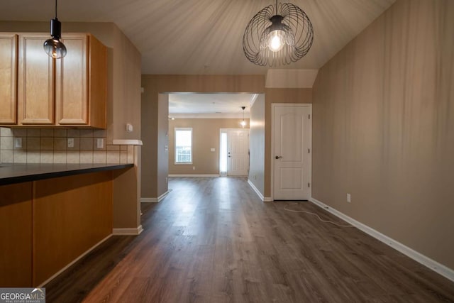96 Portico Pl, Newnan, GA 30265 - kitchen featuring baseboards, dark wood finished floors, an inviting chandelier, backsplash, and dark countertops