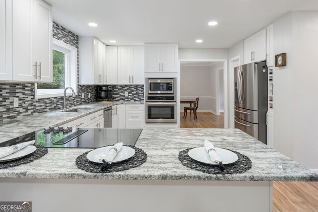 5830 Wilbanks Dr, Peachtree Corners, GA 30092 - kitchen with appliances with stainless steel finishes, a sink, backsplash, white cabinetry, and recessed lighting