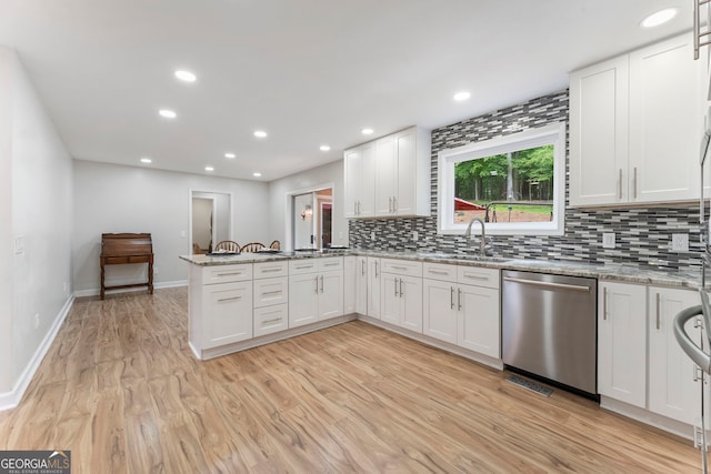 5830 Wilbanks Dr, Peachtree Corners, GA 30092 - kitchen with stainless steel dishwasher, a sink, decorative backsplash, white cabinetry, and a peninsula