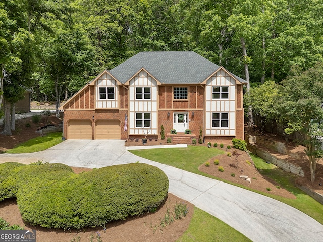5830 Wilbanks Dr, Peachtree Corners, GA 30092 - tudor-style house featuring concrete driveway, an attached garage, brick siding, a front lawn, and roof with shingles