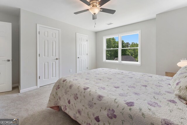 5830 Wilbanks Dr, Peachtree Corners, GA 30092 - bedroom with light colored carpet, multiple closets, baseboards, and ceiling fan