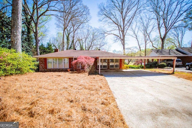 1181 Angelia Dr SW, Mableton, GA 30126 - ranch-style home with concrete driveway, a chimney, an attached carport, and brick siding