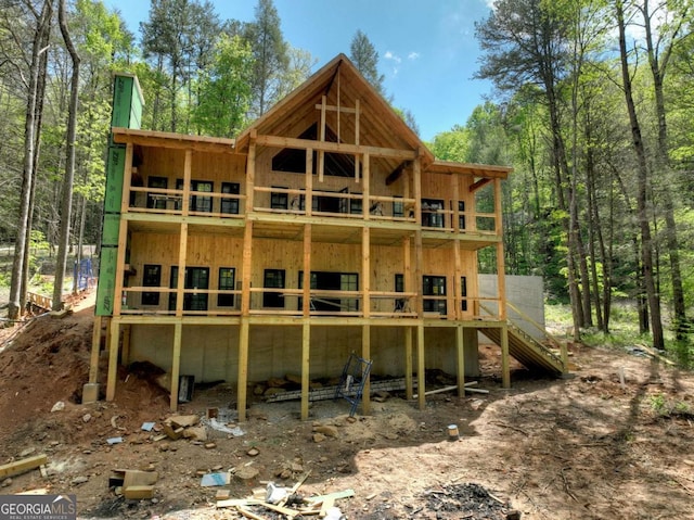 back of property with a chimney and board and batten siding