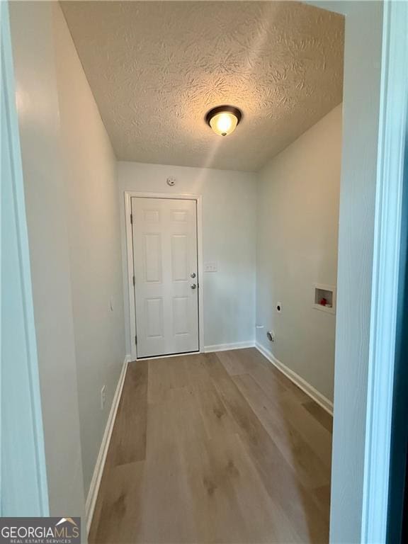 5075 Forest Downs Ln, Atlanta, GA 30349 - laundry area featuring wood finished floors, laundry area, a textured ceiling, hookup for an electric dryer, and hookup for a washing machine