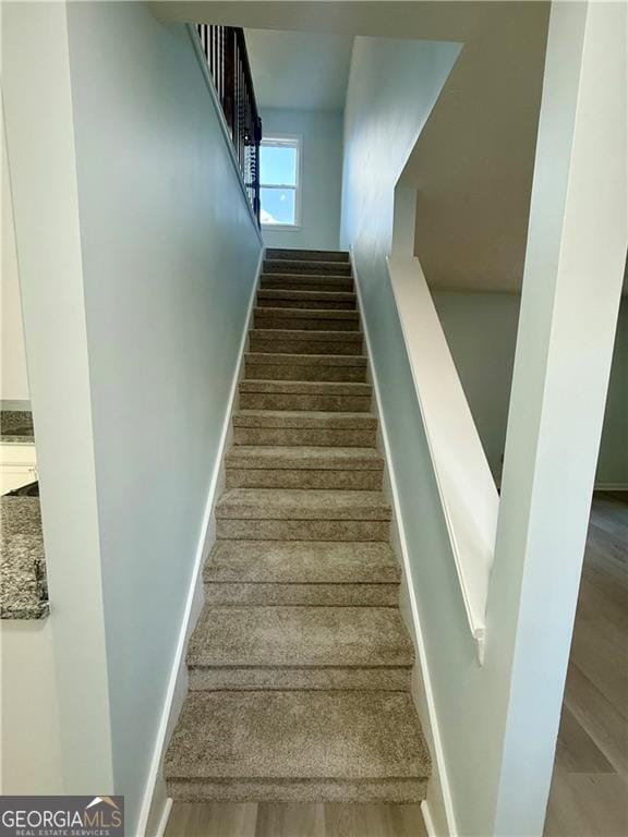 5075 Forest Downs Ln, Atlanta, GA 30349 - stairway featuring baseboards and wood finished floors