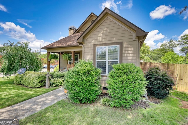 308 N Midland Ave, Monroe, GA 30655 - view of front of home featuring a chimney, roof with shingles, a front lawn, and fence