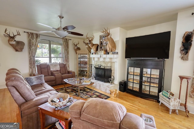 308 N Midland Ave, Monroe, GA 30655 - living room featuring a tiled fireplace, wood finished floors, and a ceiling fan