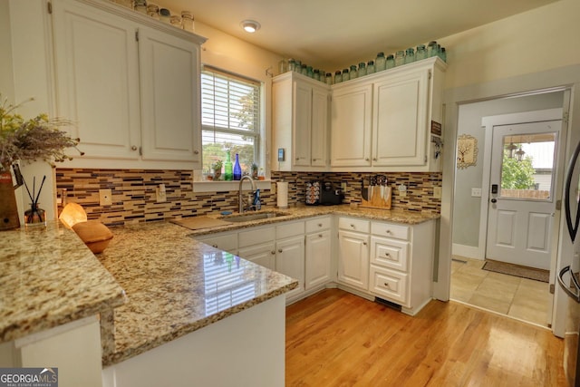 308 N Midland Ave, Monroe, GA 30655 - kitchen featuring backsplash, a wealth of natural light, light wood-style flooring, and a sink