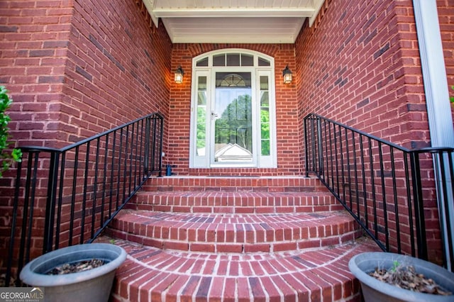 doorway to property featuring brick siding