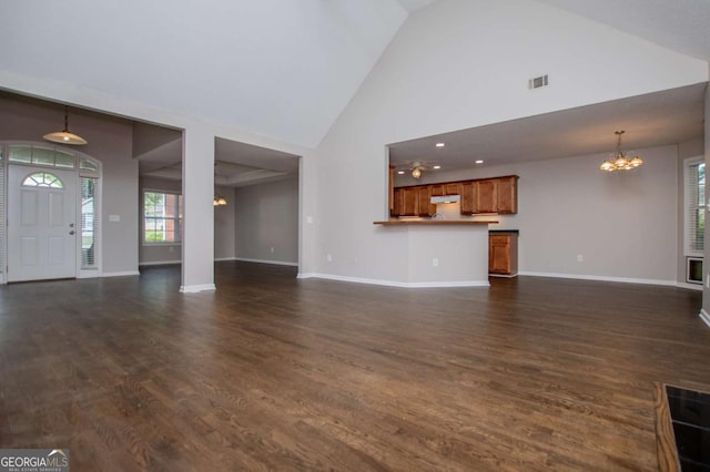unfurnished living room with baseboards, dark wood finished floors, a chandelier, and visible vents