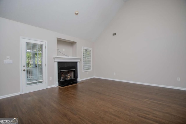 unfurnished living room featuring baseboards, a tiled fireplace, visible vents, high vaulted ceiling, and wood finished floors