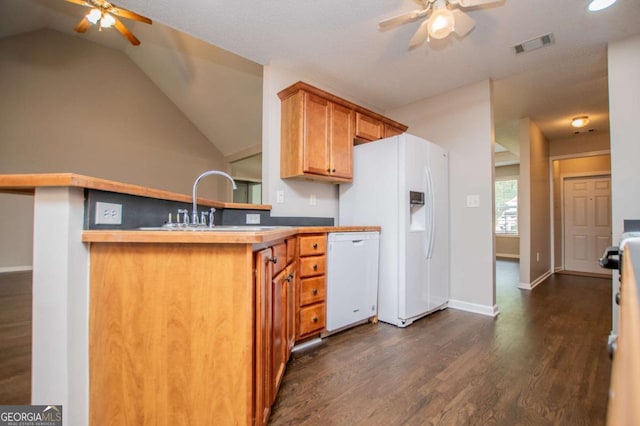 kitchen featuring a peninsula, white appliances, visible vents, ceiling fan, and dark wood-style floors