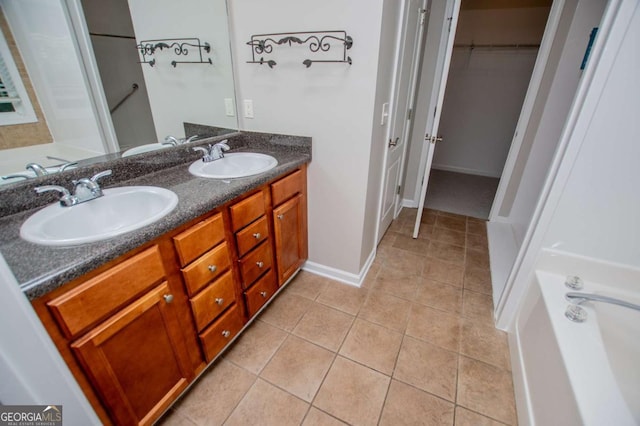 full bathroom featuring a sink, double vanity, a spacious closet, and tile patterned floors
