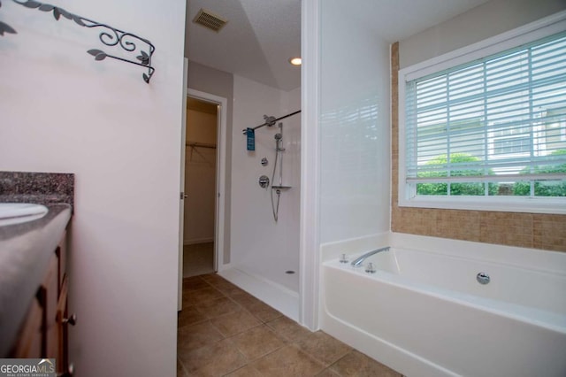 full bathroom with walk in shower, visible vents, tile patterned flooring, a spacious closet, and a bath
