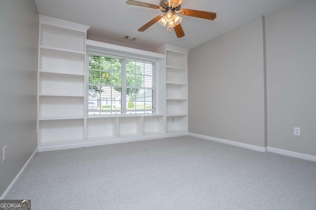 spare room featuring carpet, visible vents, baseboards, and a ceiling fan