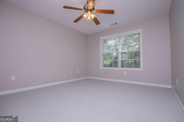carpeted spare room featuring baseboards, a ceiling fan, and visible vents