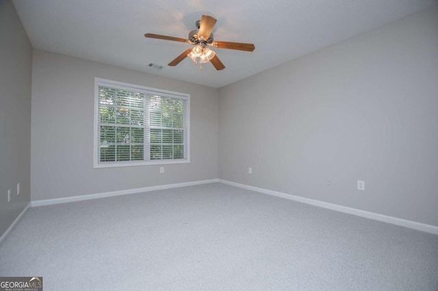 carpeted empty room featuring visible vents, baseboards, and a ceiling fan