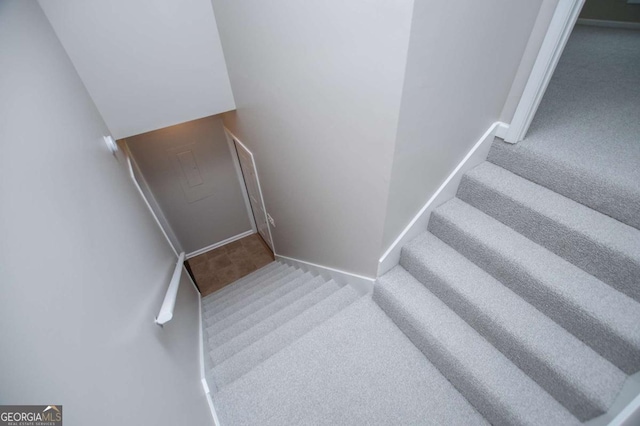 stairway featuring carpet and baseboards