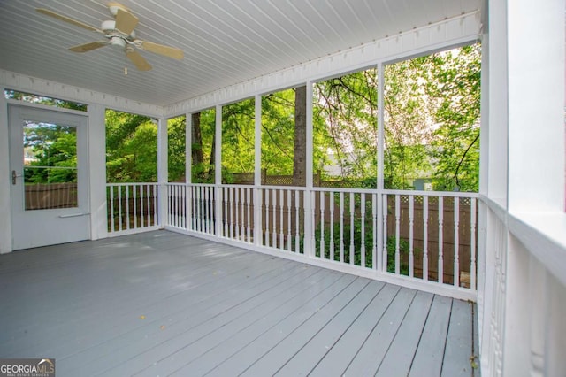 unfurnished sunroom featuring a healthy amount of sunlight and ceiling fan