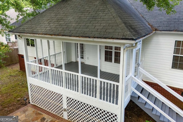 back of property with roof with shingles and a wooden deck