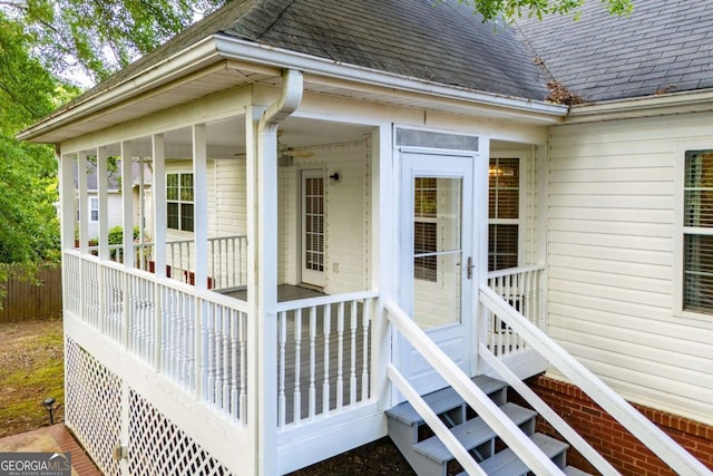 view of exterior entry featuring roof with shingles