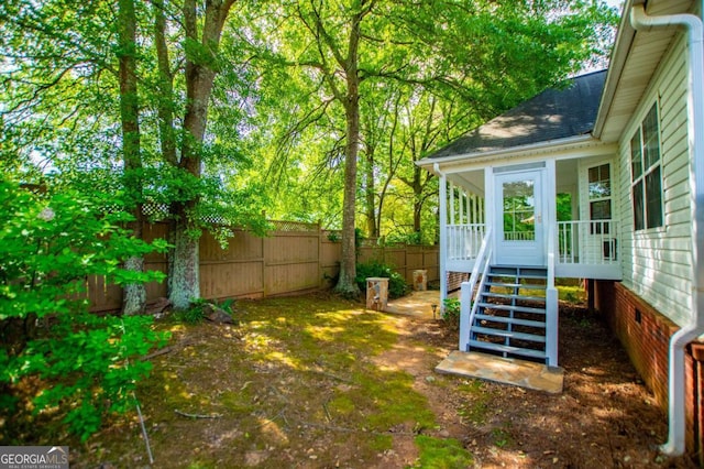 view of yard featuring a fenced backyard and a sunroom