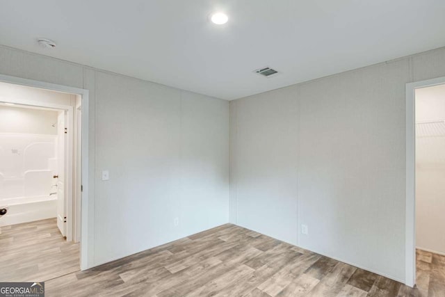 spare room featuring light wood-style floors and visible vents