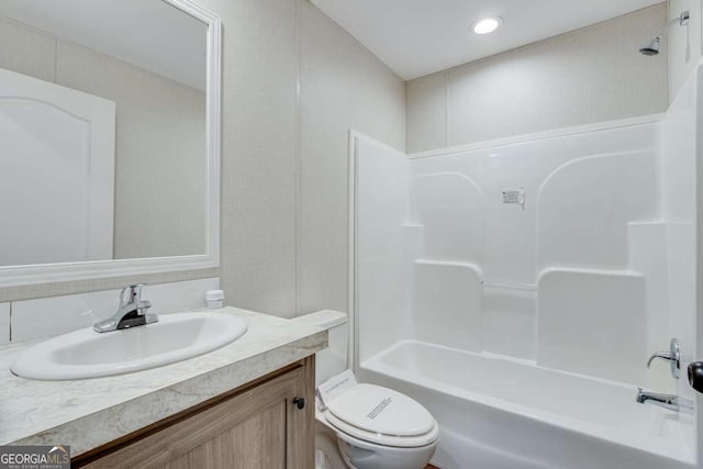bathroom with toilet, vanity, and shower / washtub combination