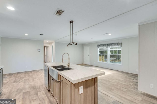 kitchen with light countertops, visible vents, light wood-style flooring, and a sink