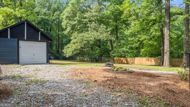 715 Wood Valley Rd, Mableton, GA 30126 - detached garage with fence, a forest view, and driveway