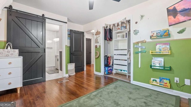 715 Wood Valley Rd, Mableton, GA 30126 - bedroom featuring a barn door, wood finished floors, baseboards, and ensuite bath