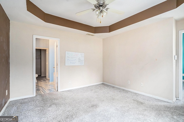 carpeted spare room featuring baseboards and ceiling fan
