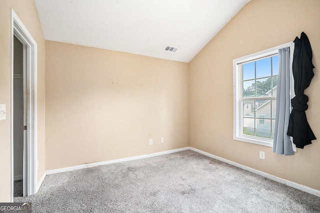 spare room with lofted ceiling, carpet flooring, and baseboards