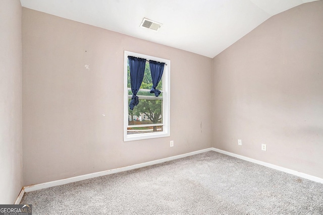 empty room with lofted ceiling, carpet flooring, and baseboards
