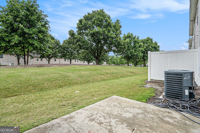 view of green lawn with a patio area and central AC unit