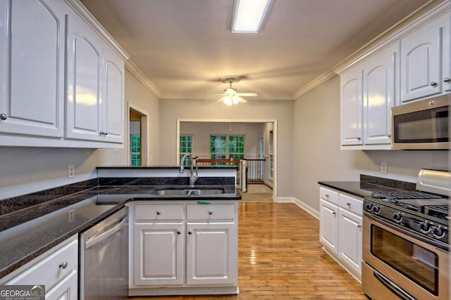 kitchen with a sink, white cabinets, and appliances with stainless steel finishes