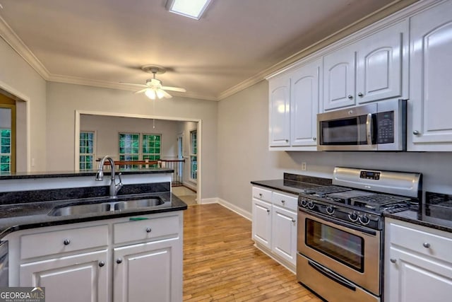 kitchen with white cabinetry, a ceiling fan, appliances with stainless steel finishes, and a sink