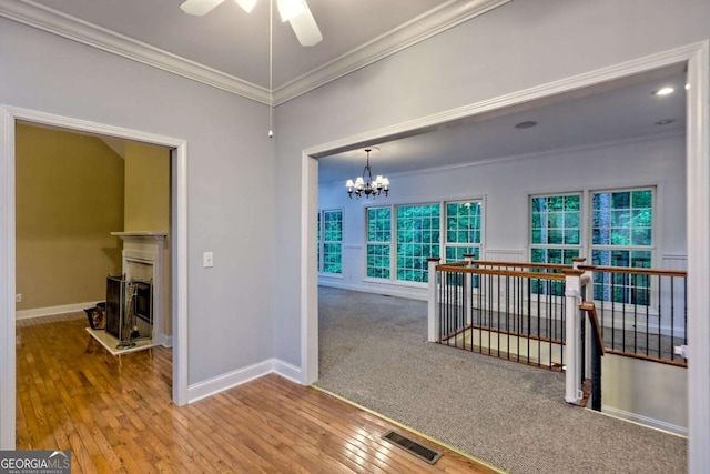 interior space with crown molding, an upstairs landing, visible vents, and baseboards