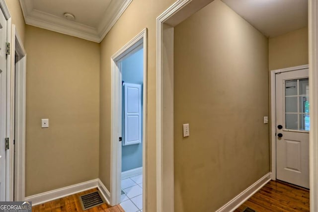entryway featuring baseboards, ornamental molding, visible vents, and dark wood-type flooring