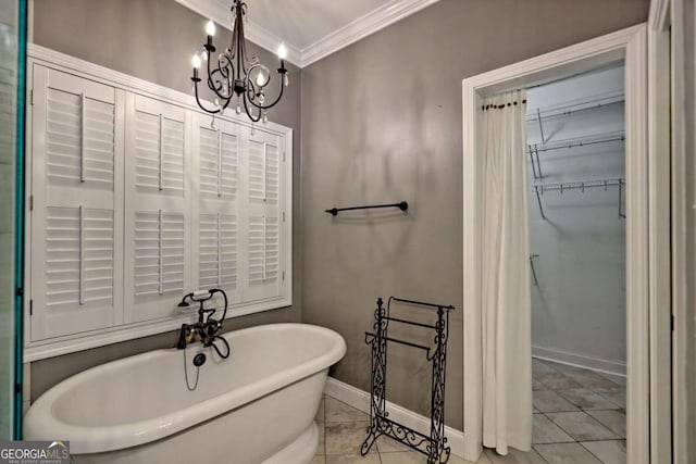 full bath featuring crown molding, tile patterned flooring, an inviting chandelier, a freestanding bath, and baseboards