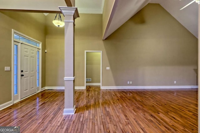 foyer featuring baseboards, visible vents, wood-type flooring, and ornate columns
