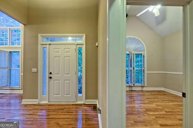 entryway featuring vaulted ceiling, ceiling fan, baseboards, and wood finished floors
