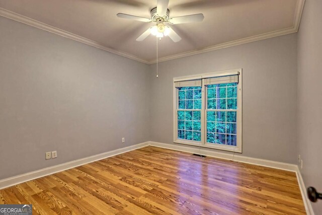 spare room with baseboards and wood finished floors
