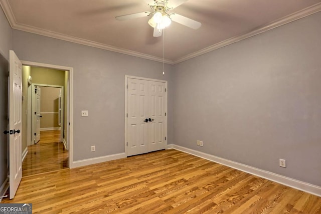 unfurnished bedroom featuring ornamental molding, light wood-style floors, and baseboards